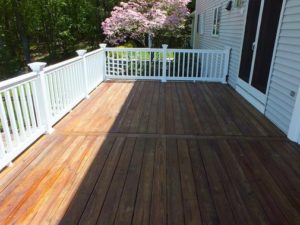A deck with wooden floors and white railing.